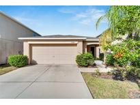 Tan single-Gathering home with a two-car garage at 17036 Peaceful Valley Dr, Wimauma, FL 33598