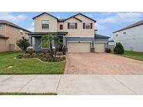 Two-story home with three-car garage and landscaped yard at 2999 Hilliard Dr, Wesley Chapel, FL 33543