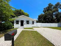 Charming bungalow with a freshly painted exterior, gravel driveway, and fenced yard at 1114 Palm Bluff St, Clearwater, FL 33755