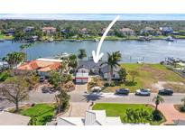 Aerial view of a waterfront home with private dock and boat at 305 Buttonwood Ln, Largo, FL 33770