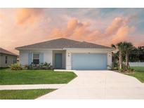 Charming one-story home with light blue garage door and well-maintained lawn at 540 Rose Apple Cir, Port Charlotte, FL 33954