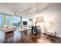 Modern living room boasts city views, dark tile floors, and comfy seating at 777 N Ashley Dr # 1808, Tampa, FL 33602