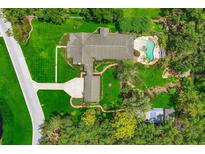 An impressive aerial view showcases the estate with lush landscaping, a pool, and winding walkways at 2501 Rustic Oaks Dr, Lutz, FL 33559