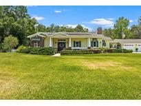Charming home with a manicured lawn, traditional design elements, and an inviting front porch at 2501 Rustic Oaks Dr, Lutz, FL 33559
