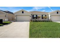 Attractive single-story home with a two-car garage and well-manicured lawn at 18027 Turning Leaf Cir, Land O Lakes, FL 34638