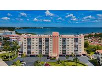 Aerial view of a waterfront condo building with parking and lush landscaping at 19029 Us Highway 19 N # 9-706, Clearwater, FL 33764