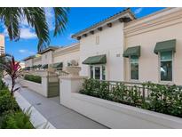 Elegant condominium exterior with lush landscaping, charming awnings, and gated entrance at 450 Knights Run Ave # 407, Tampa, FL 33602
