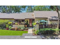 Charming home with a beautiful front yard featuring lush landscaping and a welcoming entrance at 2939 Yucca Ct, Palm Harbor, FL 34684