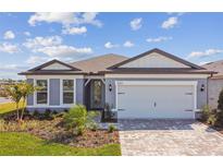 Charming single-story home boasts a brick driveway, well-kept lawn and tasteful landscaping at 11207 Shoreline Trl, Parrish, FL 34219