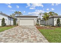 Charming home featuring a paver driveway, a two-car garage, and well-maintained landscaping at 9454 Shorebird Ct, Parrish, FL 34219