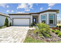 Charming one-story home with manicured lawn, paver driveway, and inviting facade at 11208 Shoreline Trl, Parrish, FL 34219