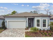 Charming single-Gathering home featuring a two-car garage, well-maintained landscaping and light-blue exterior paint at 11477 Waterway Dr, Parrish, FL 34219