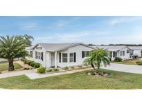 White single-wide manufactured home with palm trees and landscaping at 37652 New Horizons Blvd, Zephyrhills, FL 33541