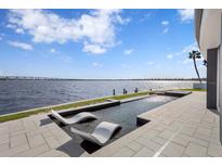 Luxury waterfront home with a modern pool and patio featuring stunning water views at 448 22Nd St, Belleair Beach, FL 33786