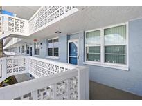 Exterior view of a condo building with a walkway and blue building at 4715 Bay Ne St # 223, St Petersburg, FL 33703