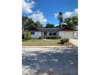 Charming ranch-style home featuring a well-maintained front yard and solar panels at 8906 Windsong Ln, Port Richey, FL 34668