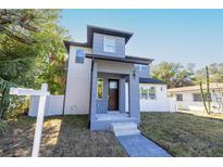 Two-story modern home with gray and white exterior, walkway, and small front yard at 1712 W Arch St, Tampa, FL 33607