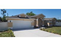Charming single-story home features a two-car garage, manicured landscaping, and a freshly painted exterior at 103 2Nd Ne Ave, Lutz, FL 33549