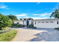 White two-story house with a three-car garage and landscaped yard at 105 Estado Ne Way, St Petersburg, FL 33704
