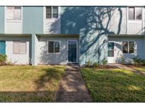 Front view of a light teal condo building with grassy lawn and walkway at 195 114Th Ne Ave # 195, St Petersburg, FL 33716