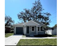 Charming home with a well-maintained front yard, mature trees, and a one-car attached garage at 2503 E 19Th Ave, Tampa, FL 33605