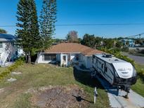 Aerial view of a single-Gathering home with a camper in the driveway and a canal in the background at 3306 Holly Springs Dr, Hernando Beach, FL 34607