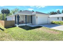 Charming single-Gathering home features a well-maintained lawn, inviting front porch, and convenient attached garage at 5714 Olive Dr, New Port Richey, FL 34652
