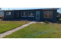 House exterior, teal door, gray siding, needs landscaping at 854 Conreid Ne Dr, Port Charlotte, FL 33952