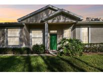 Charming house with green door and landscaped yard at 1687 Starling Drive, Tarpon Springs, FL 34689