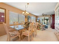 Bright dining room featuring a glass-top table, chandelier, and large windows bringing in natural light at 8019 Feather Ct # C, Hudson, FL 34667