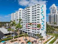 Exterior view of white condominium building with balconies and palm trees, enhanced by the blue sky at 2401 Bayshore Blvd # 410 & 510, Tampa, FL 33629