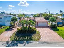 House exterior features brick driveway and waterfront view at 425 Capri Blvd, Treasure Island, FL 33706