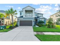 Two-story home with a well-maintained lawn, two-car garage, and an open balcony above the front entrance at 33975 Astoria Cir, Wesley Chapel, FL 33545