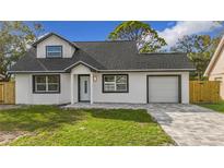 Newly renovated home with a modern exterior, featuring a gray roof and white walls at 8718 94Th St, Seminole, FL 33777