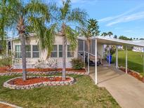 Single-wide manufactured home with carport, landscaping, and palm trees at 118 Saint Pierres Way, Apollo Beach, FL 33572