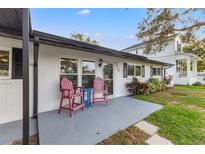 Inviting front porch with two red chairs and a small table, perfect for relaxing at 4434 W Wyoming Ave, Tampa, FL 33616