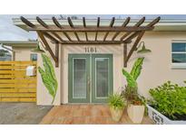 Inviting house entrance featuring a pergola, unique mural, and stylish double doors at 1161 Howard St, Clearwater, FL 33756