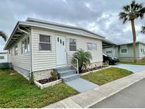 Single-wide manufactured home with carport and landscaped yard at 34185 Canal N Dr, Pinellas Park, FL 33781