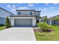 Charming two-story home featuring a gray exterior, well-manicured lawn, and an attached two-car garage at 10533 Hidden Banks Gln, Parrish, FL 34219