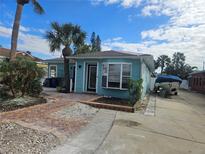 Light teal house with palm trees and boat in driveway at 610 78Th Ave, St Pete Beach, FL 33706