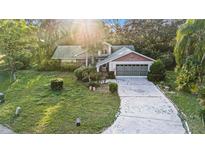 Aerial view of single-story house with driveway and mature landscaping at 8188 Forest Oaks Blvd, Spring Hill, FL 34606