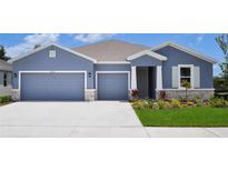 Charming home featuring a two-car garage, elegant stone accents, and nicely landscaped front yard at 16026 10Th E Ave, Bradenton, FL 34212