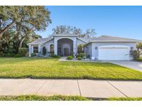 Single-story home with a landscaped lawn and attached garage at 1903 Gulf Beach Blvd, Tarpon Springs, FL 34689