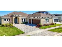 Beautiful home features a paver driveway, attached two-car garage, and well-maintained landscaping at 3901 Tour Trce, Land O Lakes, FL 34638