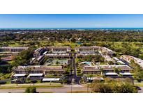 Aerial view of Villas de Golf community, showing buildings, pool, tennis court, and surrounding landscape at 12300 Vonn Rd # 9205, Largo, FL 33774