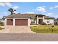 A charming single-story home with a two-car garage and well-manicured lawn at 15136 Hennipen Cir, Port Charlotte, FL 33981