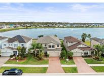 Stunning aerial view of homes surrounding a serene lake with a fountain, showcasing a desirable waterfront community at 19757 Long Lake Ranch Blvd, Lutz, FL 33558