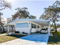 White single-wide manufactured home with carport and landscaped yard at 2331 Belleair Rd # 116, Clearwater, FL 33764