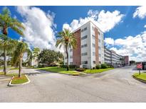 Brick building exterior, featuring palm trees and ample parking at 5501 80Th N St # 214, St Petersburg, FL 33709