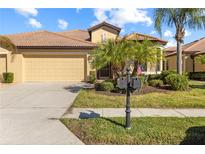 Inviting home exterior featuring a two-car garage and manicured lawn at 309 Mystic Falls Dr, Apollo Beach, FL 33572